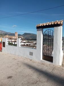 a white building with a gate on the side of it at EL RINCON DEL ROMERAL in Pegalajar
