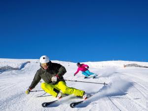 two people are skiing down a snow covered slope at NRV Top 7 in Möderbrugg