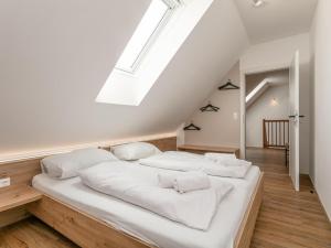 a large white bed in a room with a skylight at NRV Top 567 XL in Möderbrugg