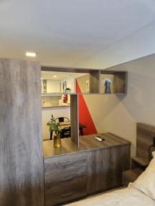 a bedroom with a large wooden cabinet and a kitchen at Altos de Barrio Martin in Rosario