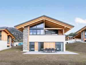 uma casa numa colina com mesas e cadeiras em Grebenzen Lodge 35 em Sankt Lambrecht