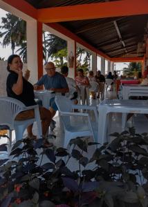 a group of people sitting at tables in a restaurant at Pousada Xaréu Maragogi in Maragogi