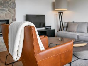 a living room with a couch and a chair with a blanket at Vista Lodge in Turracher Hohe