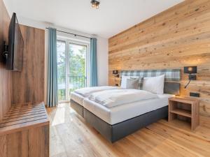 a bedroom with a large bed and a wooden wall at Vista Lodge in Turracher Hohe