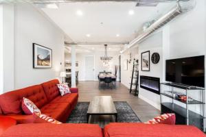 a living room with a red couch and a table at Denver suites rino arts loft - jz vacation rentals in Denver