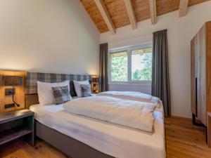 duże łóżko w sypialni z oknem w obiekcie Romantik Mountain Chalet w mieście Turracher Hohe