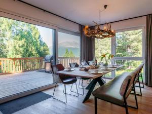 ein Esszimmer mit einem Tisch und Stühlen sowie einem großen Fenster in der Unterkunft Wanderlust Mountain Chalet in Turracher Hohe