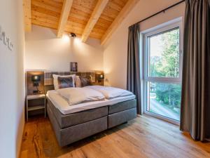 sypialnia z łóżkiem i dużym oknem w obiekcie Wanderlust Mountain Chalet w mieście Turracher Hohe