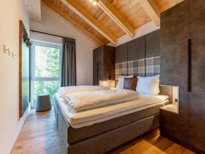 sypialnia z dużym łóżkiem i oknem w obiekcie Wanderlust Mountain Chalet w mieście Turracher Hohe