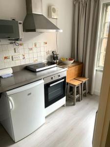 a small kitchen with a stove and a sink at Grassmarket Apartment in Edinburgh