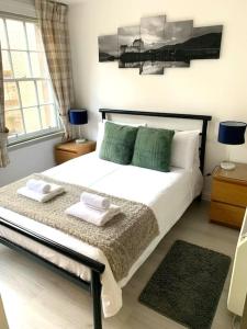 ein Schlafzimmer mit einem Bett mit zwei Handtüchern darauf in der Unterkunft Grassmarket Apartment in Edinburgh