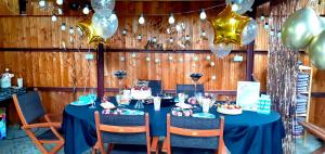 a table with a blue table cloth and balloons at Dom Pod Różami Agroturystyka in Srebrna Góra