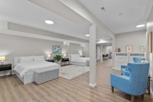 a white bedroom with a bed and a blue chair at Spacious family retreat 2 of 2 - jz vacation rentals in Tower Grove