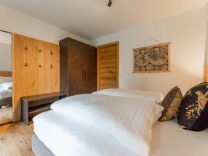 - 2 lits dans une chambre avec des placards en bois dans l'établissement Silas Mountain Chalet, à Turracher Höhe