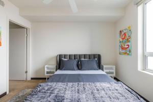 a bedroom with a large bed with blue pillows at Brand New 2BR WeHo Luxury Apartment in Los Angeles