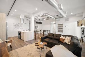 ein Wohnzimmer mit einem schwarzen Sofa und einer Küche in der Unterkunft Sweet escape luxury urban cowboy rino arts loft - jz vacations rentals in Denver