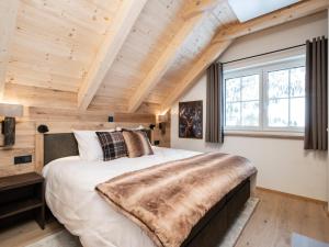 a bedroom with a large bed and a wooden ceiling at Edelweiss Lodge in Donnersbachwald