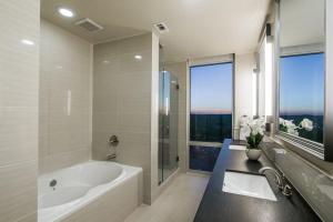a white bathroom with a tub and a sink at Casa Catherine in Austin