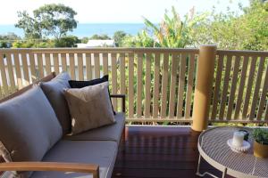 a couch sitting on a porch with a table at Buena Vista - Luxe 4 bedroom house, Views, Beach in Yeppoon