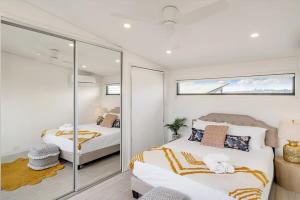 a bedroom with two beds and a glass wall at Picture-Perfect Masterpiece In Mosman in Sydney