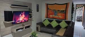 sala de estar con sofá y TV de pantalla plana en Donde Memo, en Santa Rosa de Cabal