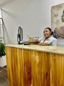 una mujer sentada en un escritorio con un ordenador en Hotel Casa Centro Historico De Cartagena Colombia, en Cartagena de Indias