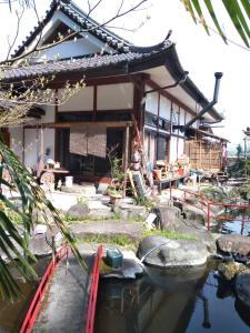 a house with a pond in front of it at COZY Inn Free Shuttle service in Nikko