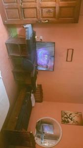 einen Blick über ein Zimmer mit einem TV und einer Treppe in der Unterkunft Hospedaje Marlenis in Managua