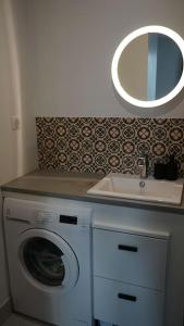 uma casa de banho com uma máquina de lavar roupa e um lavatório em Appartement au cœur du Marais em Paris