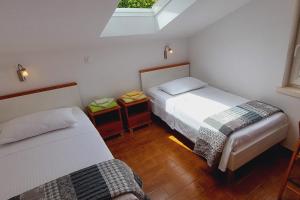 - une chambre avec 2 lits et une lucarne dans l'établissement Apartments by the sea Korcula - 21883, à Korčula