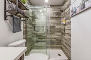 a bathroom with a glass shower with a toilet at Cozy 3br downtown red door house in Jeffersonville