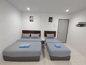 two beds with blue pillows in a room at 184 GURNEY DRIVE PENANG in George Town