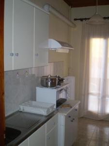 a kitchen with a sink and a stove with a pot on it at Hotel Apolafsi in Volos