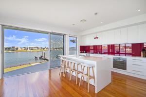 a kitchen with white cabinets and a large window at 484 The Anchorage Port Macquarie in Port Macquarie