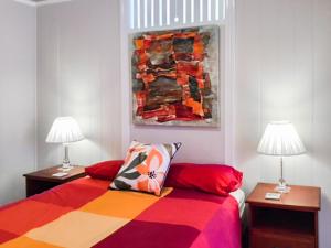 a bedroom with a bed with two tables and two lamps at West End Luxury 4B3B Home w Parking and Home Pod Music System M9 in Brisbane