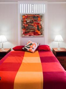 a bedroom with a colorful bed with two lamps at West End Luxury 4B3B Home w Parking and Home Pod Music System M9 in Brisbane