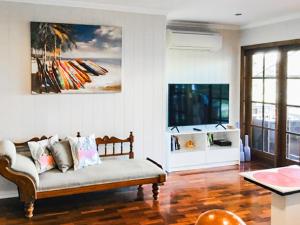 a living room with a couch and a tv at West End Luxury 4B3B Home w Parking and Home Pod Music System in Brisbane