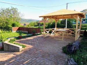 cenador de madera con mesa de picnic en un patio de ladrillo en Golubina 2 - Studio Apartman, en Golubac