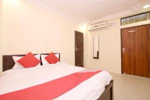 een slaapkamer met een groot bed met rode kussens bij OYO Hotel Vn Residency in Jabalpur