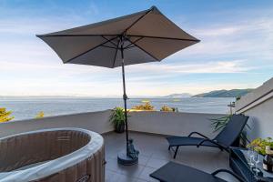 une terrasse avec un parasol, une table et des chaises dans l'établissement Seaside holiday house Prigradica, Korcula - 21988, à Blato