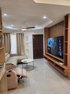 een woonkamer met een bank en een flatscreen-tv bij Riverduplex - Luxury duplex at a fair price in Dauis