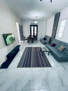 un soggiorno con divano blu e TV di Chalets and apartments Al-Nawras Village Ismailia a Ismailia