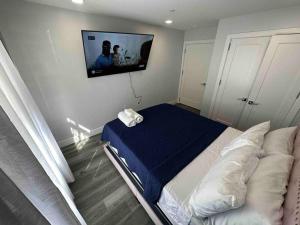 a bedroom with a bed and a tv on the wall at The Classic Suite: 2BR close to NYC in Paterson