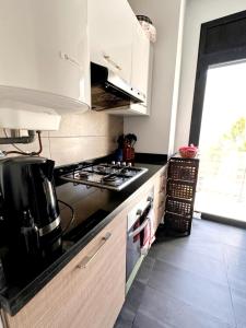 a kitchen with a stove top oven next to a window at Rest, sea and sun in Agadir