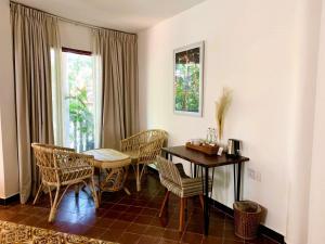 uma sala de jantar com uma mesa e cadeiras e uma janela em Jungle Addition em Phnom Penh