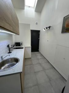 アジャクシオにあるStudio 2 Personnes Plein Centre Rue Piétonneの白いキッチン(シンク、ドア付) +10枚の写真