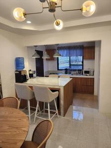 een keuken met een tafel en stoelen en een aanrecht bij Riverduplex - Luxury duplex at a fair price in Dauis