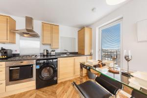 a kitchen with a washer and dryer at Mearns Street Suite ✪ Grampian Lettings Ltd in Aberdeen