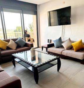 a living room with couches and a glass coffee table at Rest, sea and sun in Agadir +40 photos