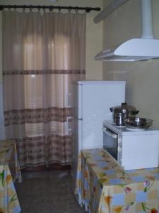a kitchen with a refrigerator and a table and a stove at Hotel Apolafsi in Volos